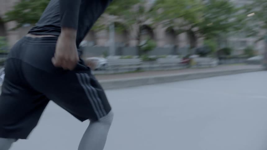A young black man runs across a basketball court