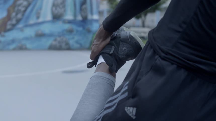 Young african american man stretches on basketball court