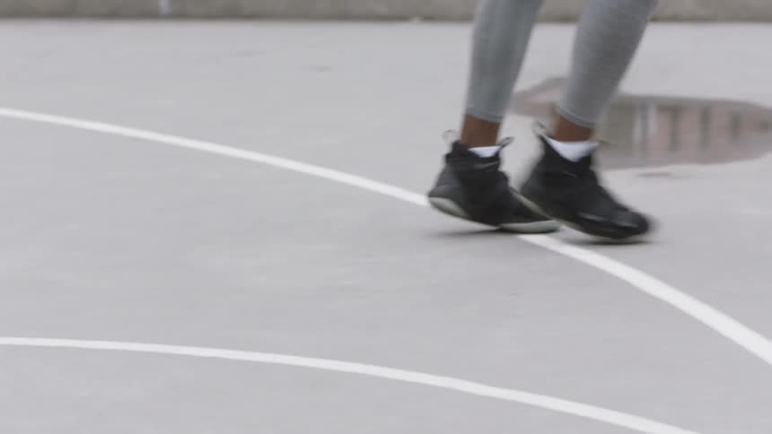 A young black man dribbles a basketball