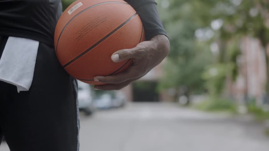 A mans hand holding a basketball