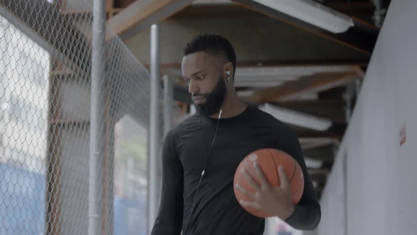 Man walking down the hallways bouncing a ball