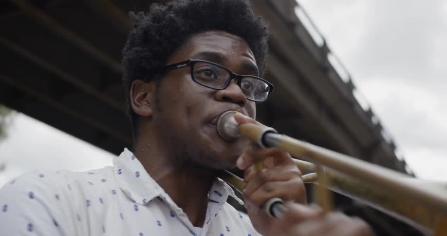 A man outside playing the trombone