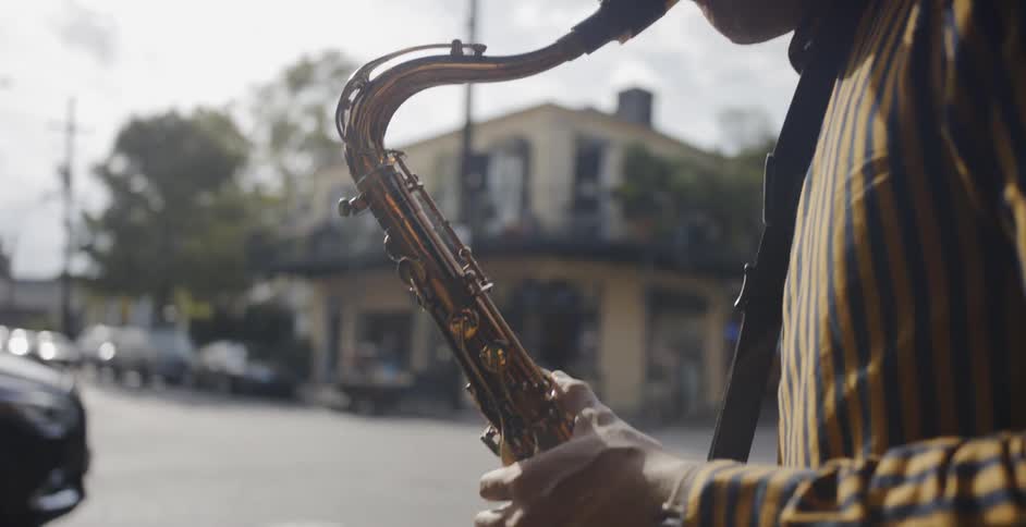 A teenager playing the saxophone by the street