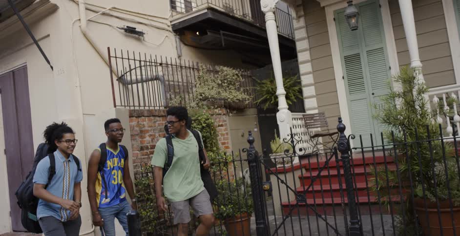 Three young men walk down the street