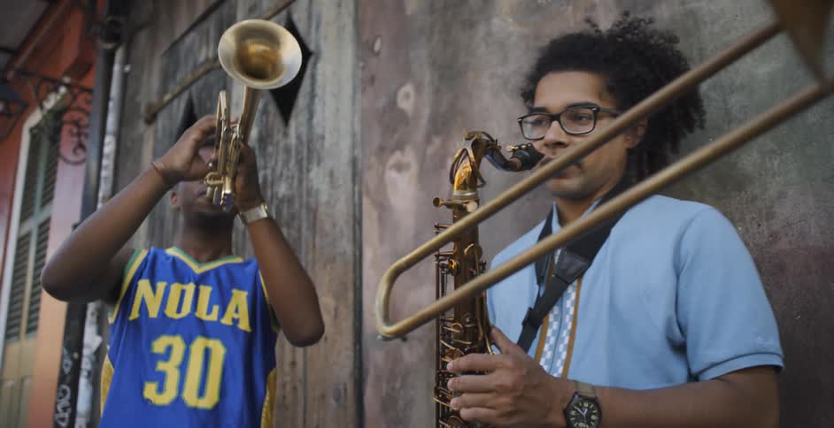 Three black man play saxophone outdoors in the daytime