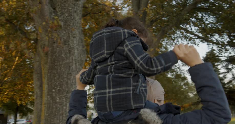 A woman carries the child on top of her shoulders