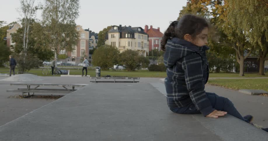A toddler girl climbing down off a table