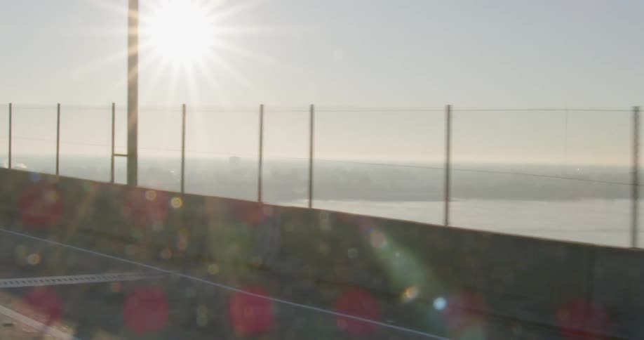View from vehicle driving on large bridge over wide river