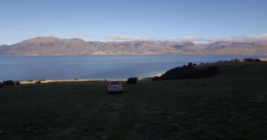 A car drives towards a lake