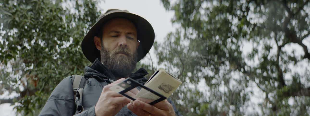Man makes notes while standing outdoors