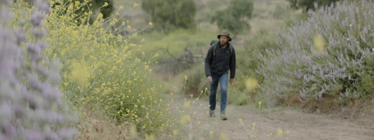 A man walks up a trail