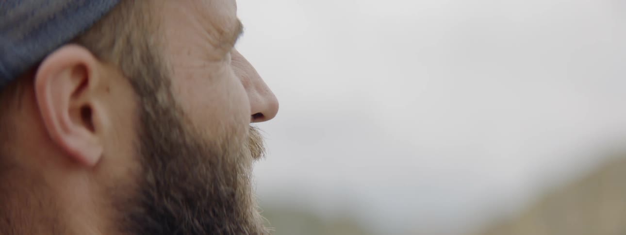A man wearing a hat stares at something off camera