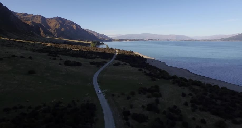 A car drives down an ocean side road