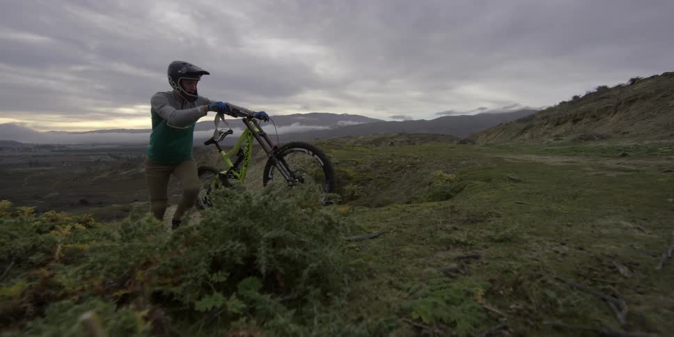 A person walking a bike uphill
