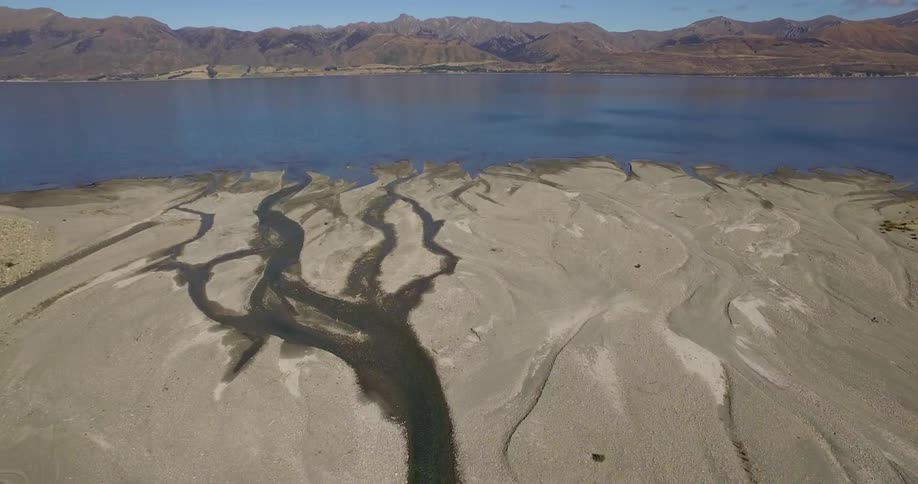 Calm water rests along a mountain lined shore