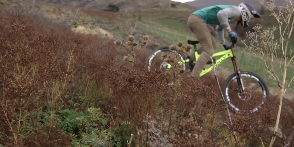 A bmx rider descends down a hillside