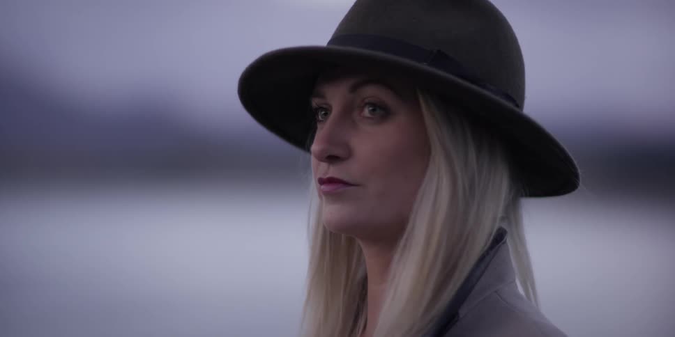 A woman is shown with a hat and piercing