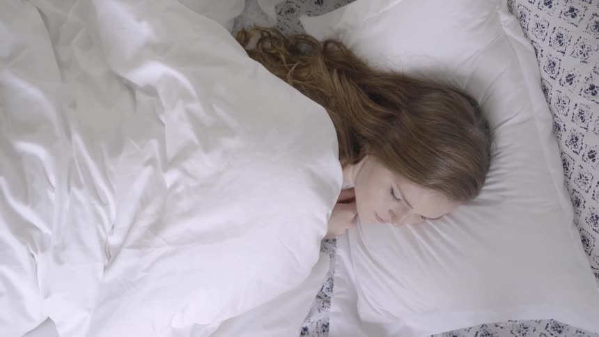 Woman lays down on bed
