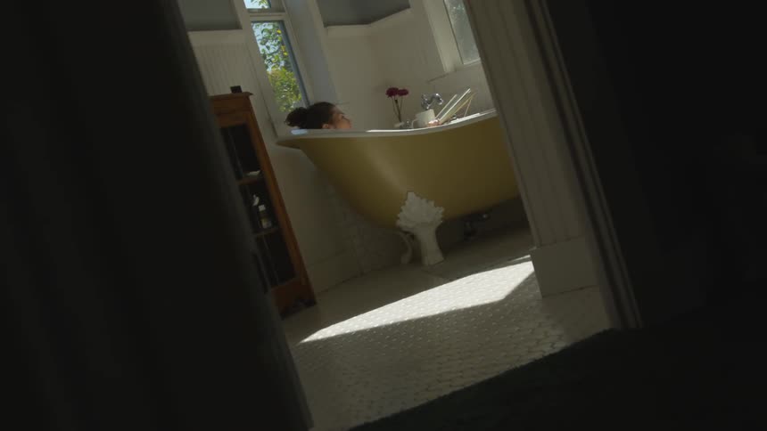 A woman sitting in a bathtub relaxing