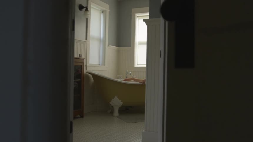 A person relaxes in a clawfoot bathtub