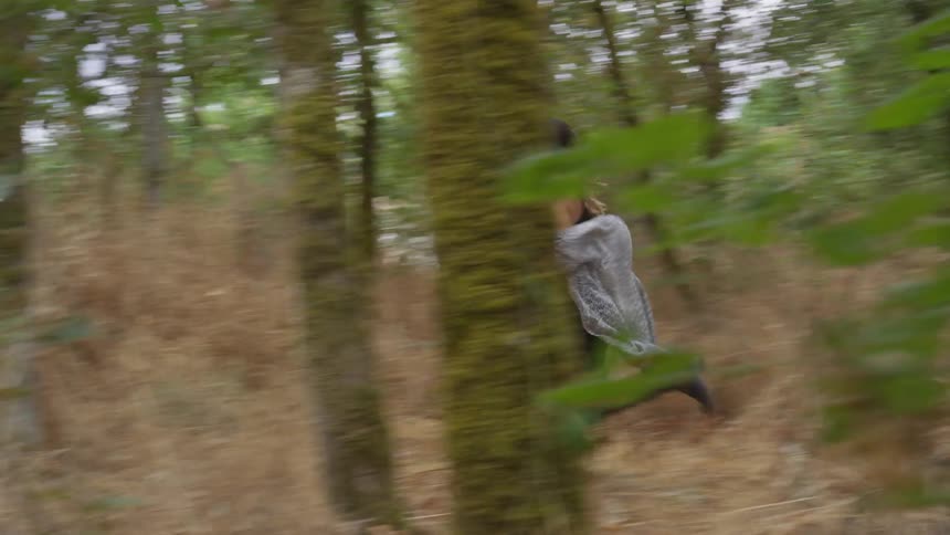Woman running through the woods in the daylight