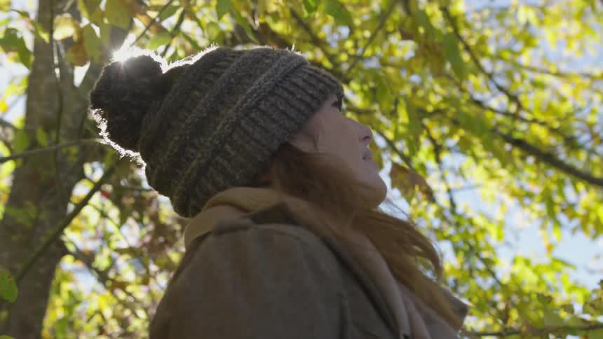 A woman is outdoors looking up