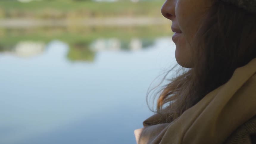 Close up of a woman standing near to a lake