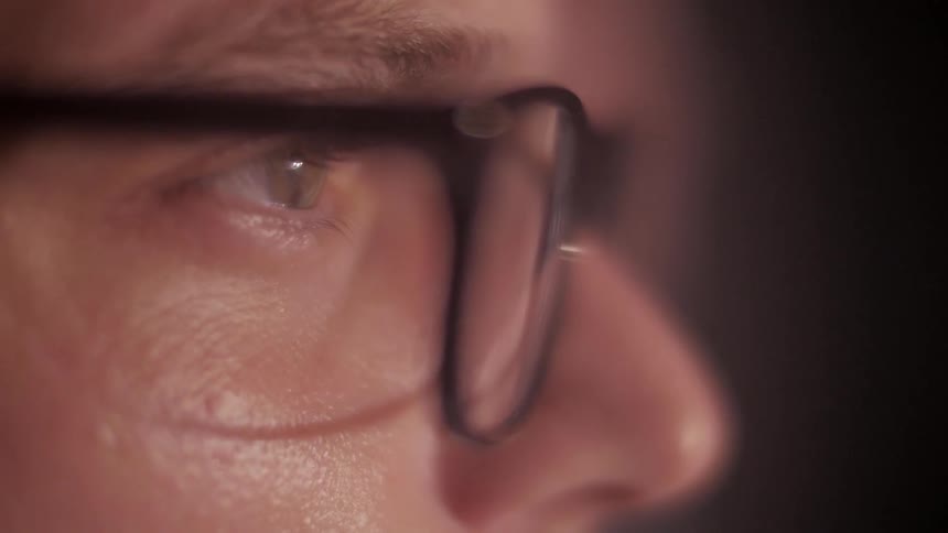Close view of a man wearing eyeglasses while staring