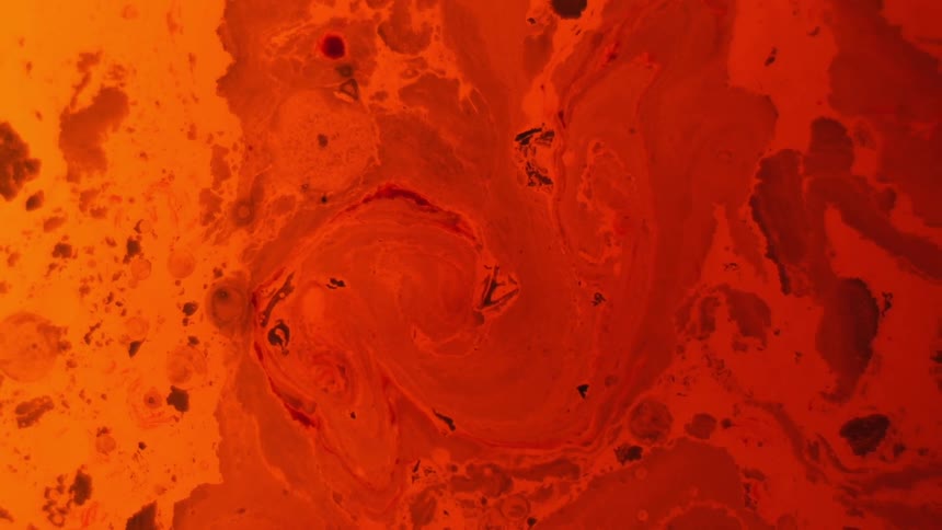 Swirls are forming in a body of orange liquid