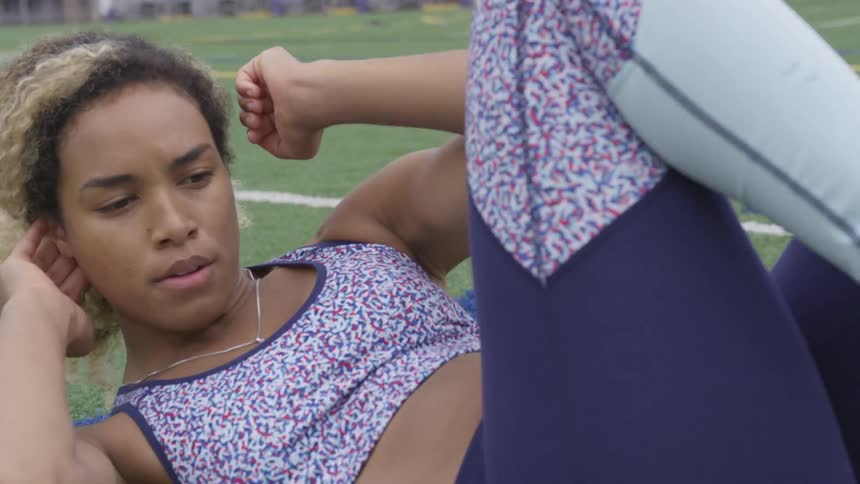 A young woman exercises on a field