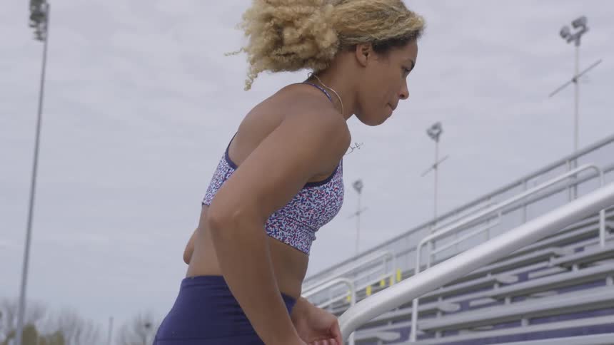 A female running up bleachers
