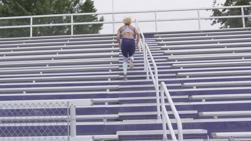A woman running up bleachers