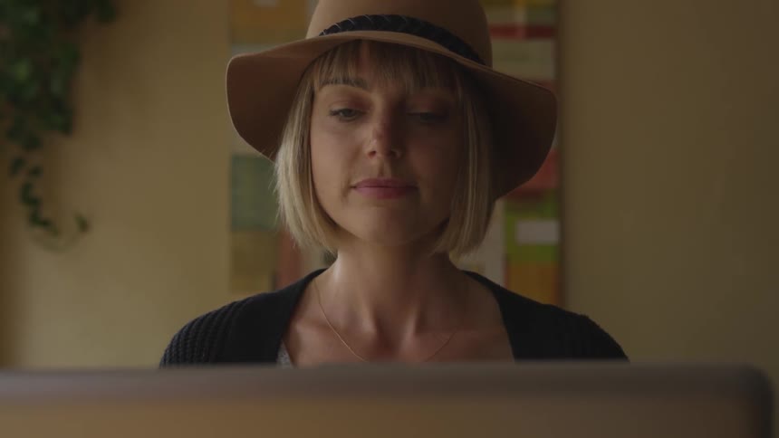 A woman smiles while looking around the room