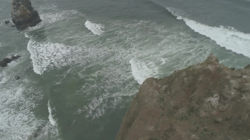 Waves rolling into a rocky shoreline during the day