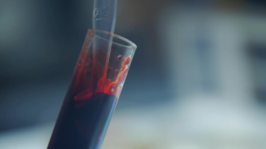 Red liquid is pipetted from a test tube