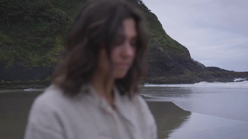 Woman standing on a beach on a cloudy day