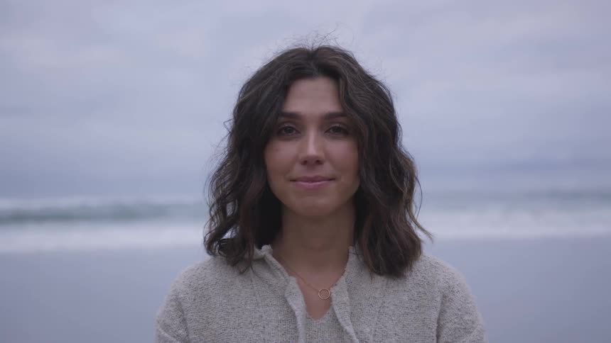 A woman standing at the edge of the coast