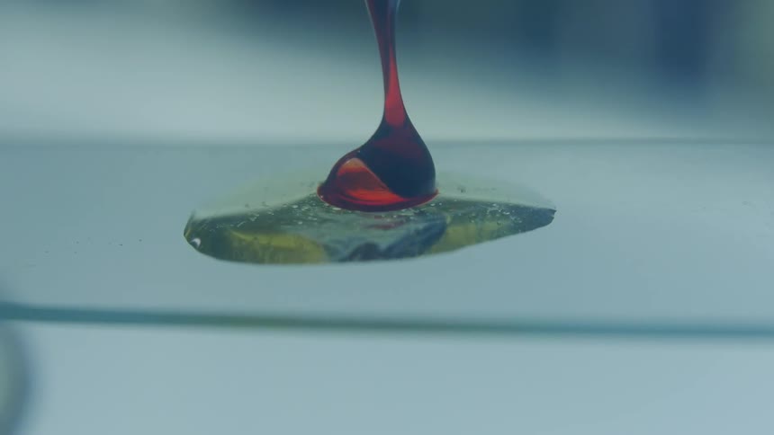 Red fluid dropped onto a microscope slide