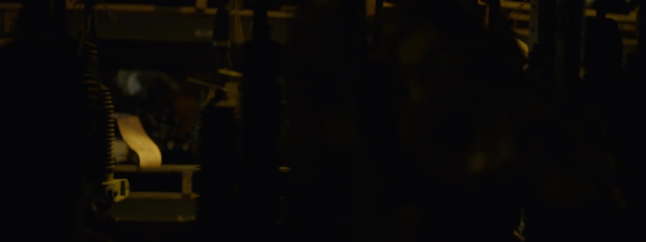 The young man is walking in the warehouse of tools looking down the aisles assessing them closely