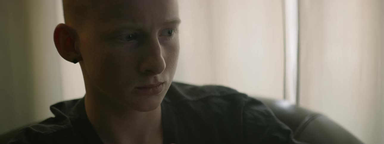 A young boy sits and looking sad