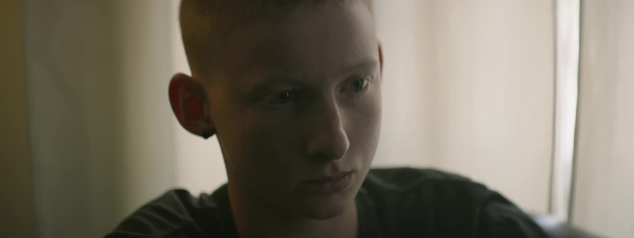 A boy sitting and staring blankly forward