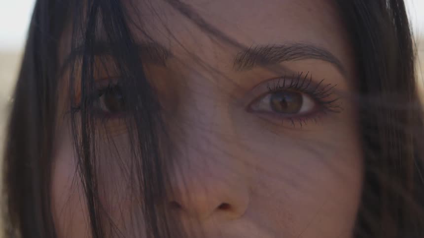A woman standing outdoors during the day looking into the camera