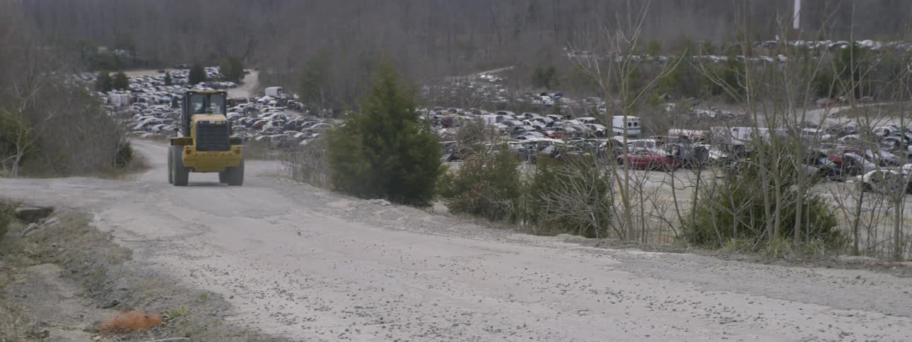 Tractor drives down dirt road