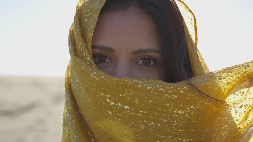 A woman in a yellow vail standing outside