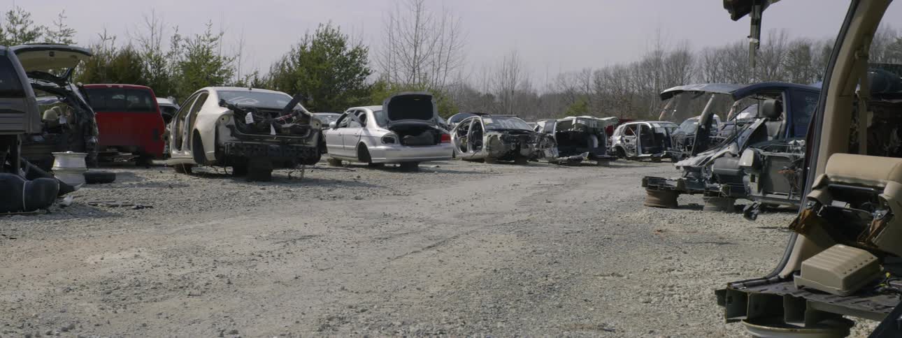A junk yard that is full of old broken cars