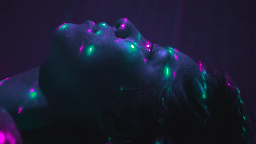 Person lays with lights strobing over face