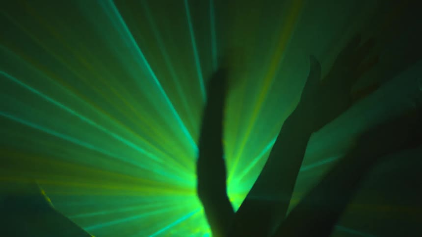 Four hands and arms swaying through laser beams