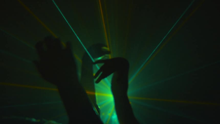Hands move in the air while strobe lights are going
