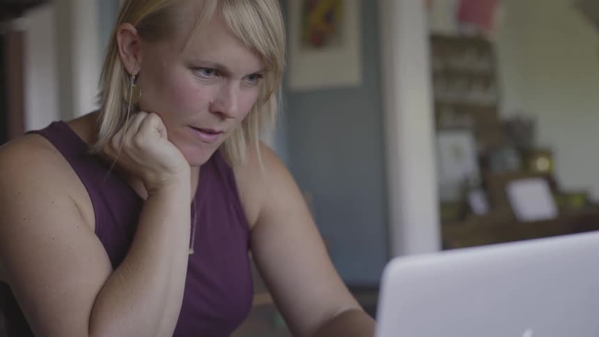 Woman reading from her laptop and nodding her head