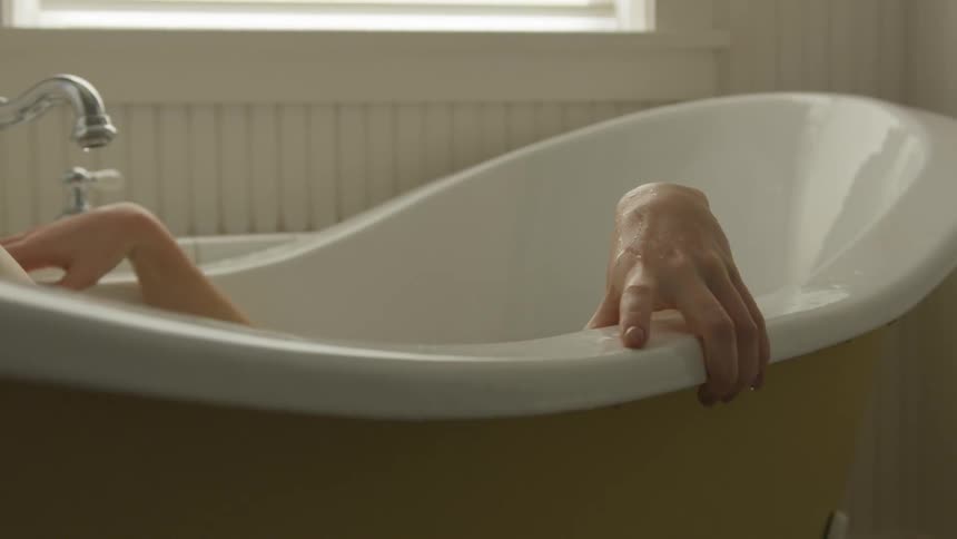 A woman sits in a bubble bath
